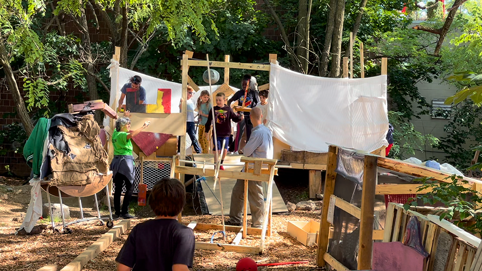 Children storm out of the castle they built during the final day of the Medieval school break workshop.